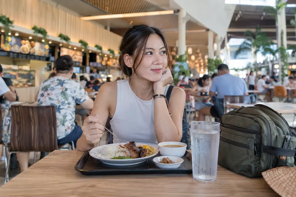 セブの明るいフードコートで食事をしながら次の予定を考える旅行者