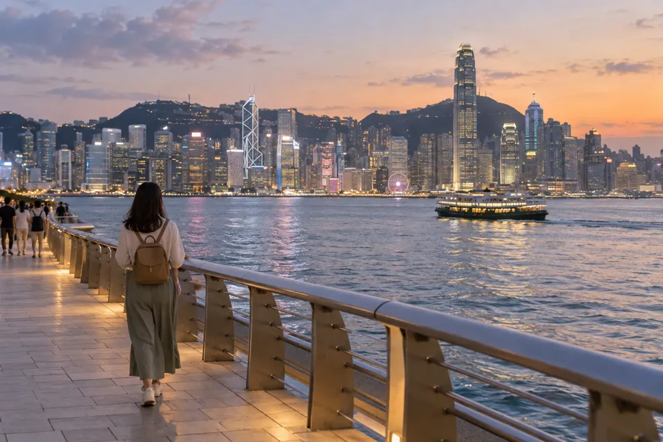 尖沙咀の海沿いから香港島を眺める旅行者