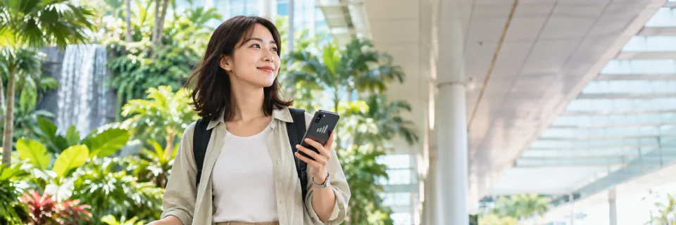 空港到着後にスマートフォンを確認しながら移動する旅行者